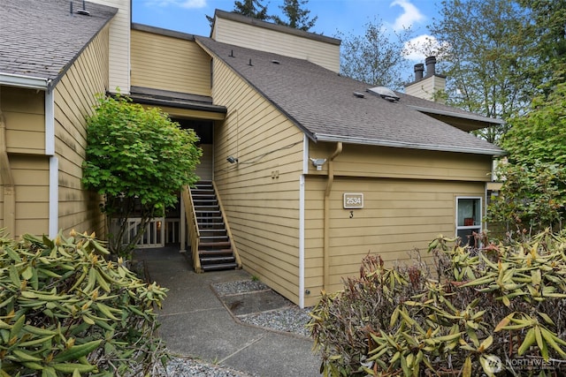 2534 S 317th St Unit 103, Federal Way, WA 98003 - back of house featuring stairway, roof with shingles, and a chimney
