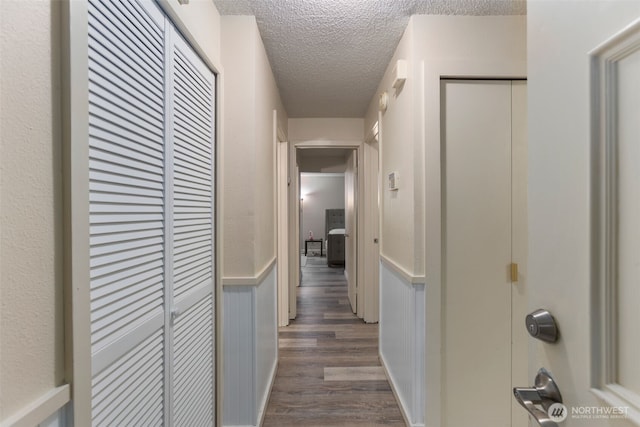 2534 S 317th St Unit 103, Federal Way, WA 98003 - hall with a wainscoted wall, a textured ceiling, and dark wood-type flooring