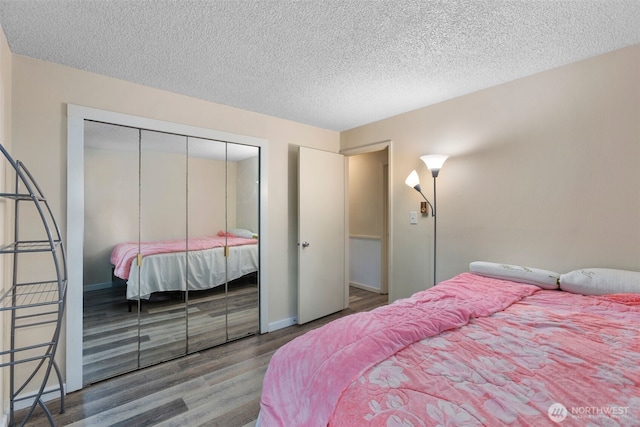 2534 S 317th St Unit 103, Federal Way, WA 98003 - bedroom with a textured ceiling, wood finished floors, baseboards, and a closet
