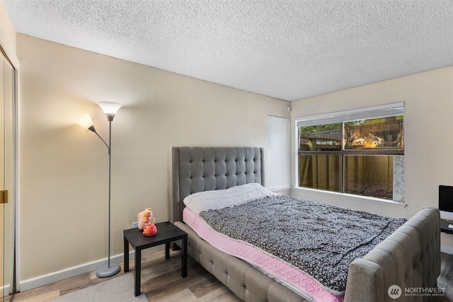 2534 S 317th St Unit 103, Federal Way, WA 98003 - bedroom featuring a textured ceiling, wood finished floors, and baseboards