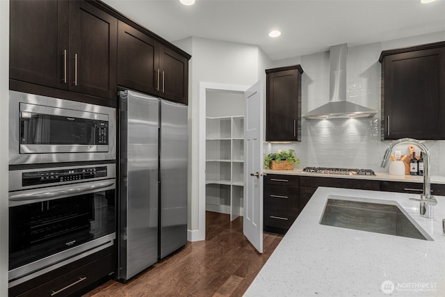 1221 199th St SE, Bothell, WA 98012 - kitchen featuring appliances with stainless steel finishes, wall chimney range hood, a sink, dark brown cabinets, and recessed lighting