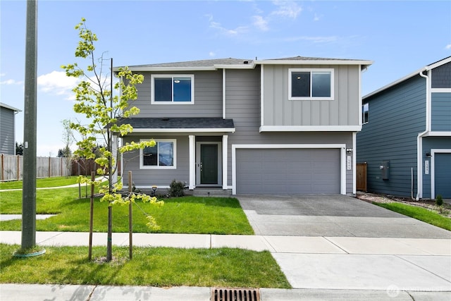 traditional home with board and batten siding, a front yard, a garage, fence, and concrete driveway