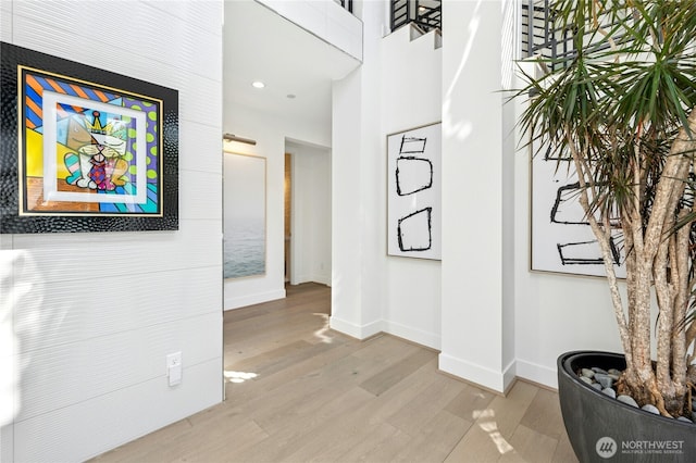 hallway featuring wood finished floors, recessed lighting, and baseboards
