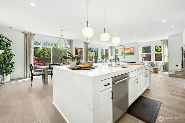 kitchen with recessed lighting, a sink, light wood-style floors, a center island with sink, and dishwasher