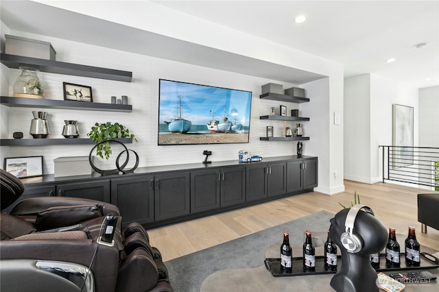 living area featuring baseboards, light wood-type flooring, and recessed lighting