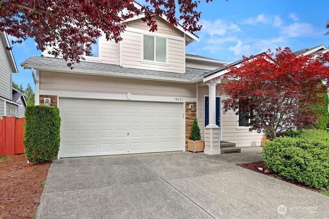 view of front of house featuring an attached garage, roof with shingles, fence, and driveway
