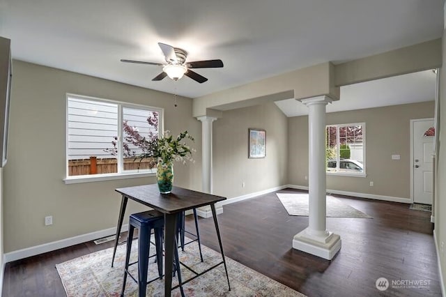 dining room featuring baseboards, ceiling fan, ornate columns, and dark wood-style floors