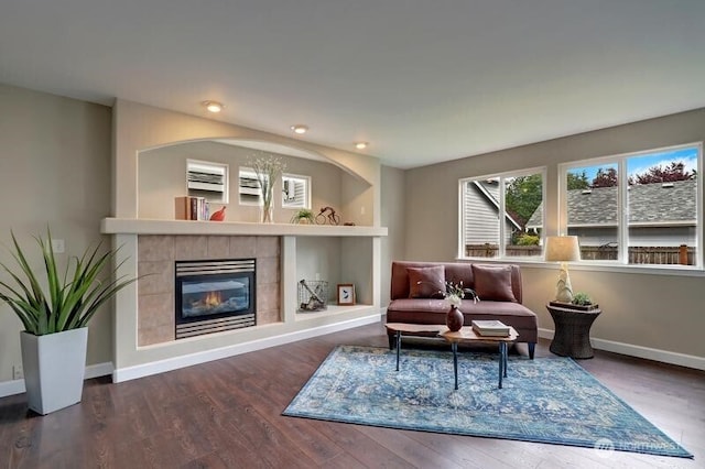 living room featuring recessed lighting, baseboards, wood finished floors, and a tile fireplace
