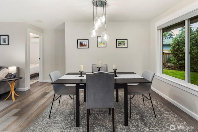 dining room with baseboards, an AC wall unit, and wood finished floors