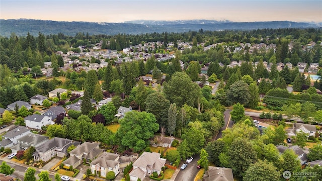 drone / aerial view featuring a view of trees and a residential view