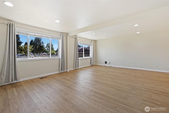 spare room with light wood finished floors, recessed lighting, and baseboards