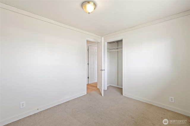 unfurnished bedroom with carpet flooring, baseboards, and a closet