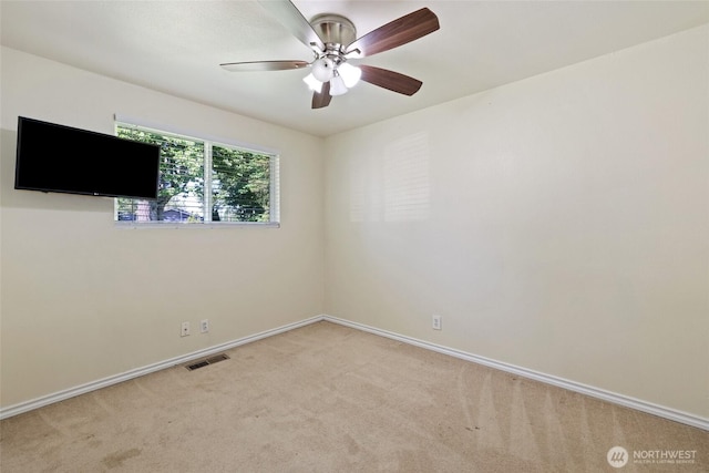 empty room featuring light colored carpet, ceiling fan, and baseboards