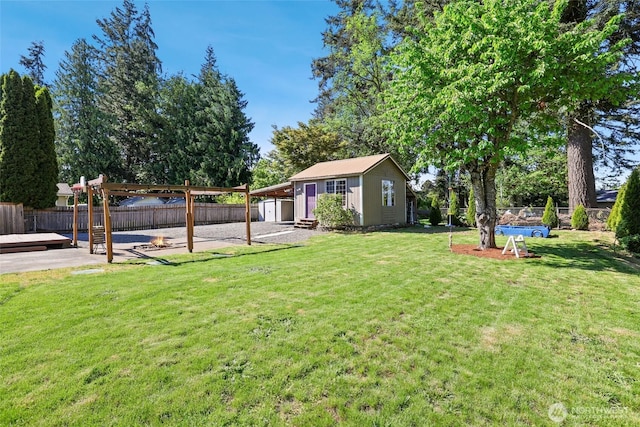 view of yard with an outbuilding, a storage unit, a pergola, and a patio area