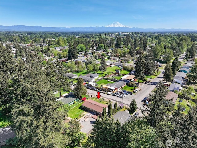 aerial view of property and surrounding area with a mountainous background and nearby suburban area
