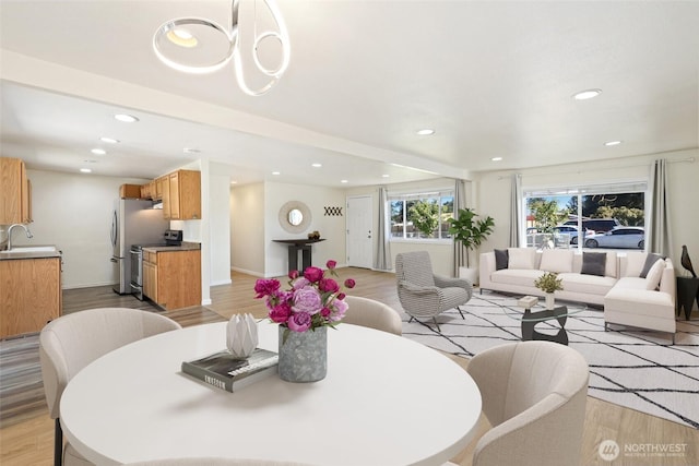 dining space featuring light wood finished floors, recessed lighting, and baseboards
