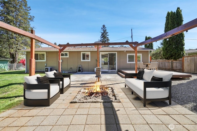 rear view of house featuring an outdoor living space with a fire pit, a patio, and stucco siding