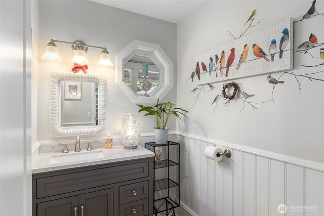 bathroom with vanity and a wainscoted wall