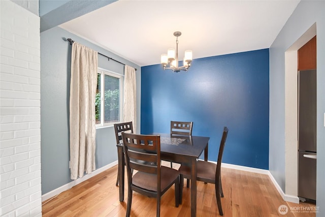 2858 32nd Ave W Unit 102, Seattle, WA 98199 - dining space with light wood-style floors, baseboards, and a chandelier