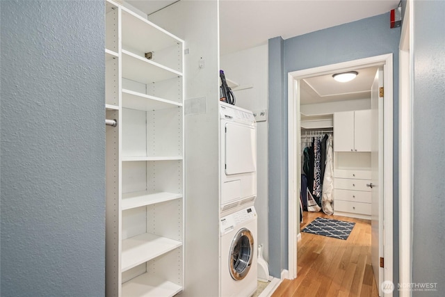 2858 32nd Ave W Unit 102, Seattle, WA 98199 - laundry area featuring laundry area, a textured wall, stacked washer / dryer, and wood finished floors