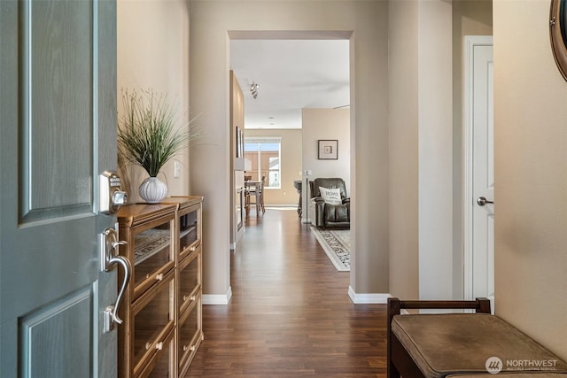 hall with dark wood-style floors and baseboards