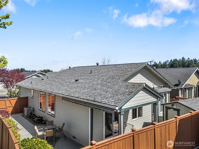 back of property with a patio, a shingled roof, crawl space, central AC, and a fenced backyard
