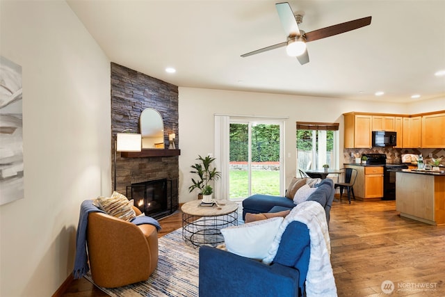 3639 Reagan Ave, Bremerton, WA 98310 - living room featuring wood finished floors, a stone fireplace, ceiling fan, and recessed lighting