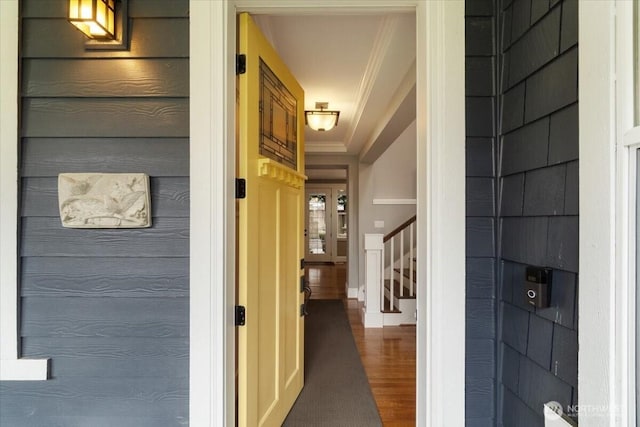 hall featuring wood finished floors, stairway, and crown molding
