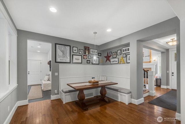corridor with wainscoting, baseboards, wood finished floors, and recessed lighting