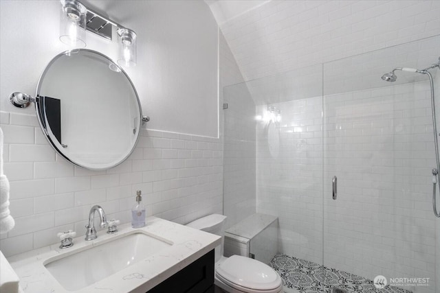 full bath featuring toilet, tile walls, backsplash, a shower stall, and vanity