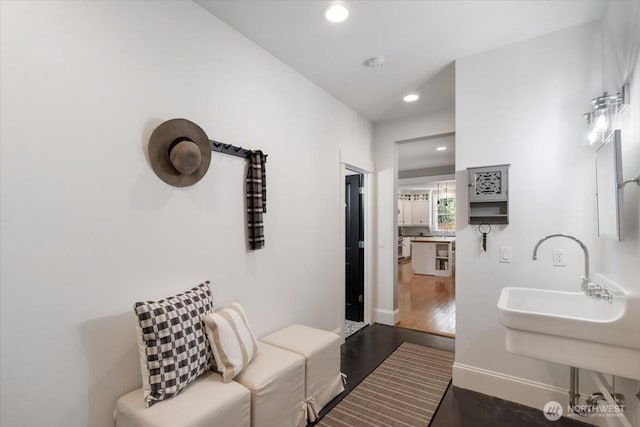interior space with baseboards, wood finished floors, and recessed lighting
