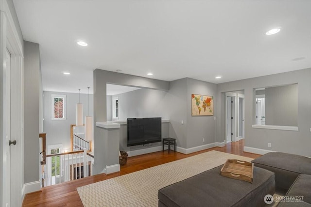 living room with visible vents, baseboards, wood finished floors, and recessed lighting