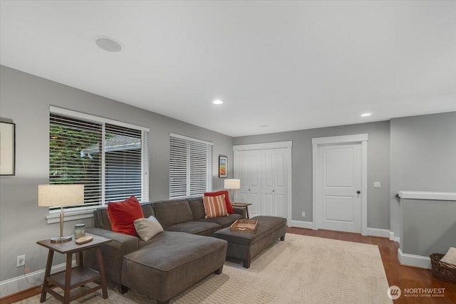 living area with baseboards, wood finished floors, and recessed lighting