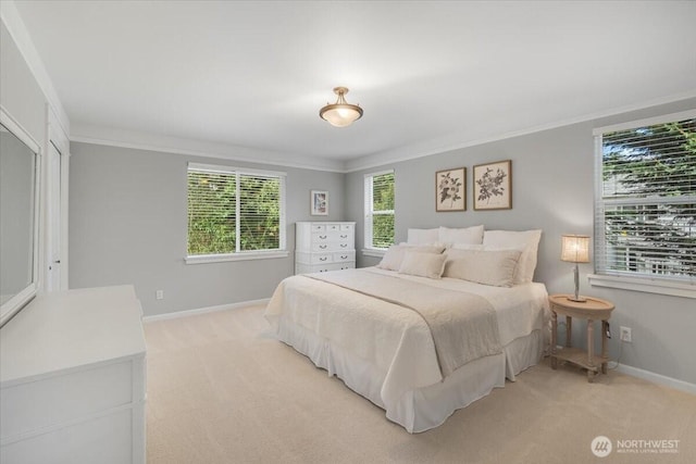 bedroom with baseboards, light colored carpet, and multiple windows