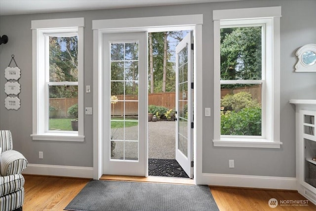 doorway to outside with baseboards and wood finished floors
