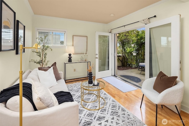living area featuring plenty of natural light, wood finished floors, and crown molding