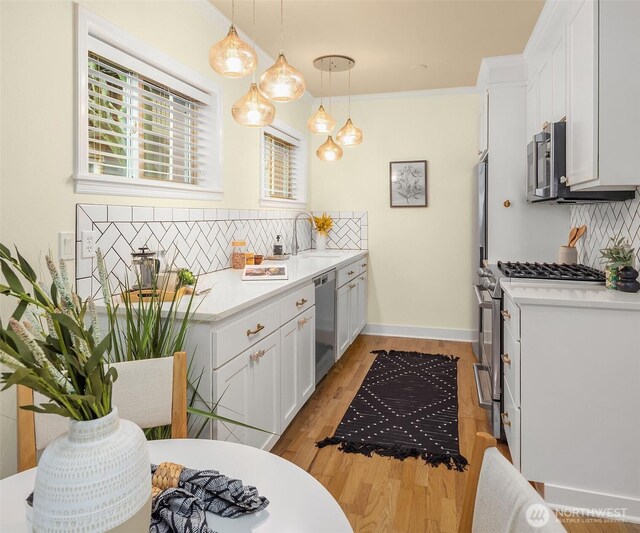 kitchen featuring white cabinets, tasteful backsplash, stainless steel appliances, and a sink