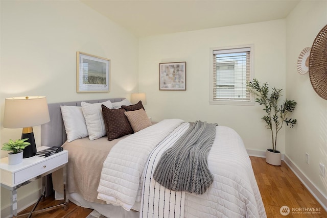 bedroom featuring wood finished floors and baseboards