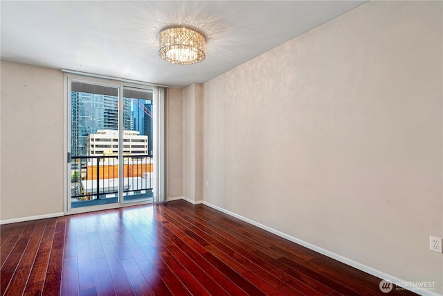 177 107th Ave NE Unit 1501, Bellevue, WA 98004 - unfurnished room with a chandelier, baseboards, dark wood-type flooring, and floor to ceiling windows