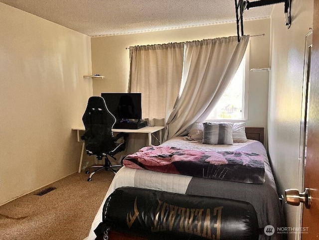 bedroom featuring carpet floors, a textured ceiling, and visible vents