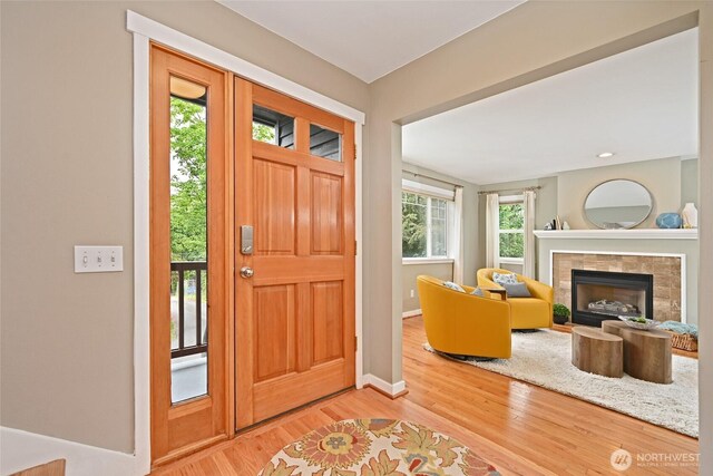 10839 35th Ave SW, Seattle, WA 98146 - foyer entrance with light wood-style floors, baseboards, and a tiled fireplace