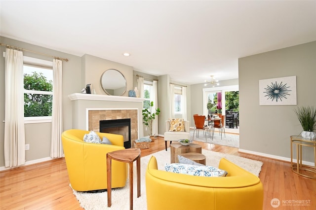 10839 35th Ave SW, Seattle, WA 98146 - living area featuring light wood-style floors, a tiled fireplace, baseboards, a chandelier, and recessed lighting