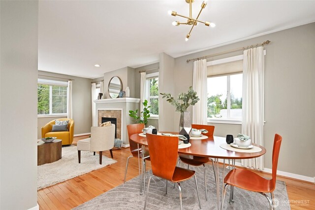 10839 35th Ave SW, Seattle, WA 98146 - dining space featuring wood finished floors, a tile fireplace, a chandelier, and baseboards