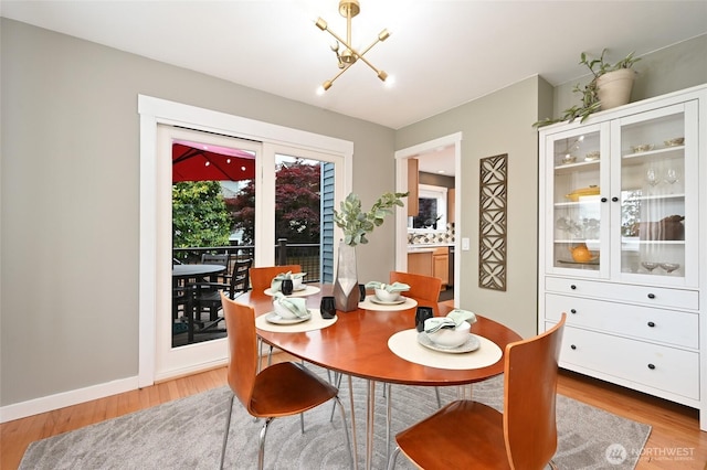 10839 35th Ave SW, Seattle, WA 98146 - dining space featuring a chandelier, light wood-style flooring, and baseboards