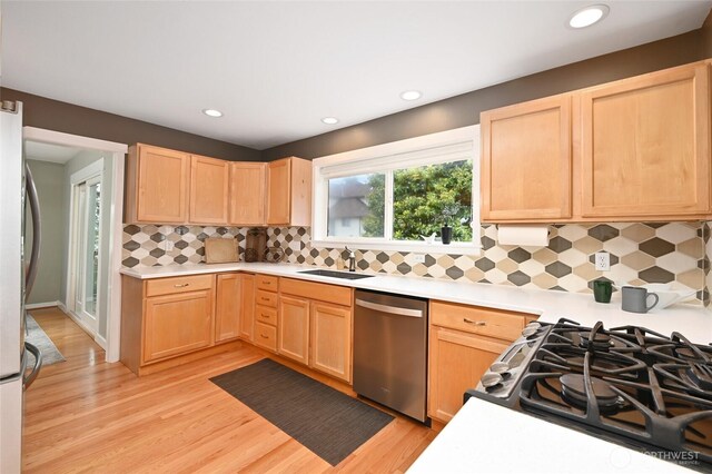 10839 35th Ave SW, Seattle, WA 98146 - kitchen with stainless steel appliances, light brown cabinetry, light countertops, light wood-type flooring, and recessed lighting