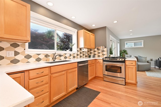 10839 35th Ave SW, Seattle, WA 98146 - kitchen featuring appliances with stainless steel finishes, a sink, light brown cabinets, light wood-style floors, and recessed lighting
