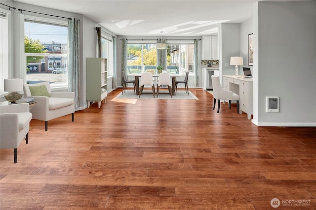 dining area featuring baseboards, heating unit, and wood finished floors