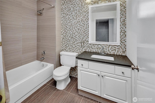 full bathroom featuring tasteful backsplash, tile patterned floors, vanity, tile walls, and toilet