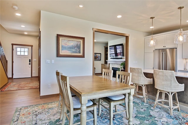 dining area with recessed lighting, baseboards, wood finished floors, and a fireplace
