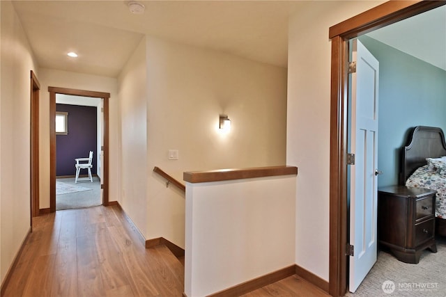 hall with light wood-style floors, baseboards, recessed lighting, and an upstairs landing